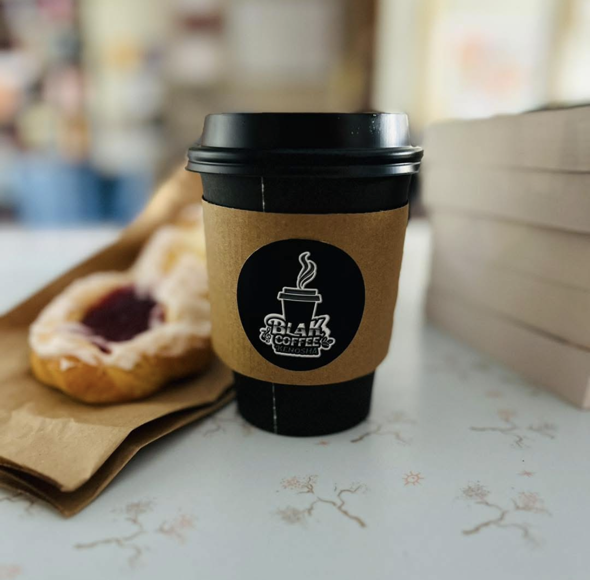 A BLAK Coffee cup served beside a pastry